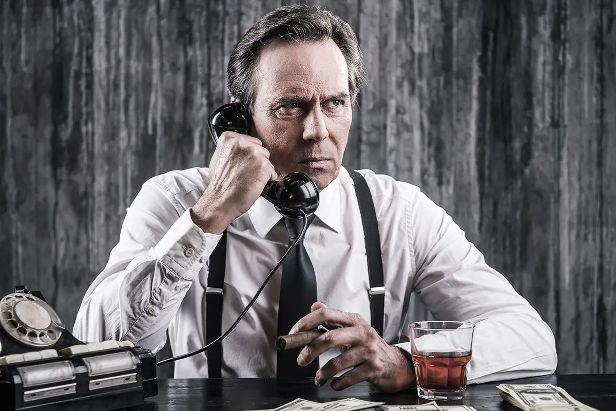 The Rise of Teleconferencing A man sitting at the desk, talking on the corded phone